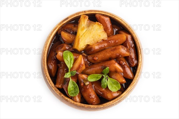 Tteokbokki or Topokki, fried rice cake stick, popular Korean street food with spicy jjajang sauce and pineapple isolated on white background. Top view, flat lay