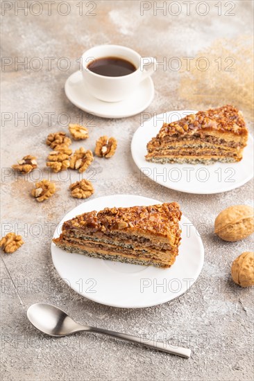 Walnut and hazelnut cake with caramel cream, cup of coffee on brown concrete background. side view