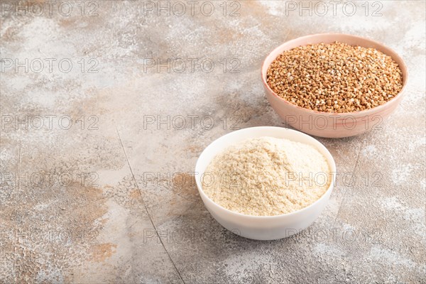 Powdered milk and buckwheat baby food mix, infant formula on brown concrete background. Side view, copy space, artificial feeding concept