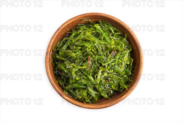 Chuka seaweed salad in brown wooden bowl isolated on white background. Top view, flat lay