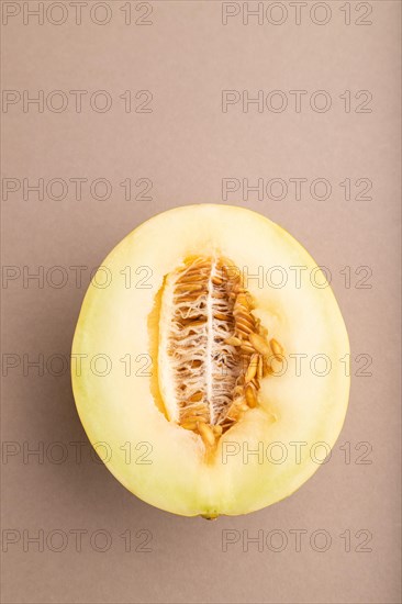 Sliced ripe yellow melon on brown pastel background. Top view, flat lay, copy space. harvest, women health, vegan food, concept, minimalism