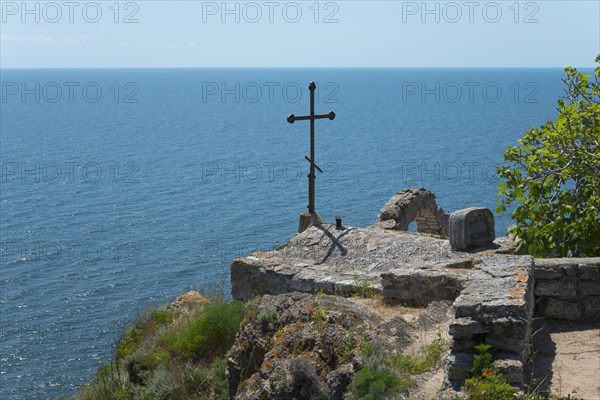 A simple cross overlooks the calm sea from a rocky cliff, Chapel of St Nicholas, Cape Kaliakra, Dobruja, Black Sea, Bulgaria, Europe