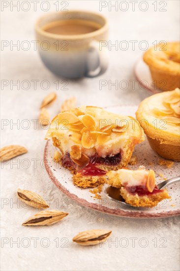 Traditional portuguese cakes pasteis de nata, custard small pies with almonds with cup of coffee on gray concrete background. Side view, close up, selective focus