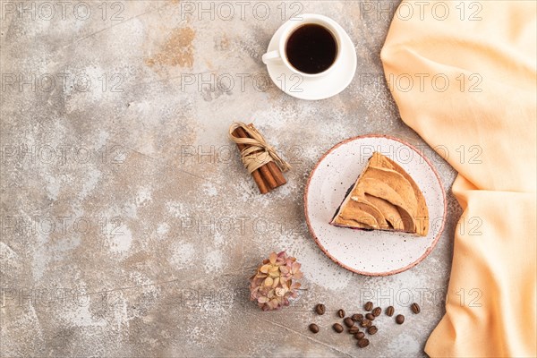 Zephyr or marshmallow cake with cup of coffee on brown concrete background and orange textile. top view, flat lay, copy space