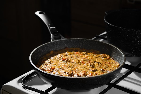 Hot mushroom pie with chicken meat taken out of oven is cooling on top of gas stove