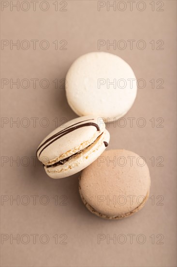 Brown and white macaroons on beige pastel background. top view, flat lay, close up, still life. Breakfast, morning, concept
