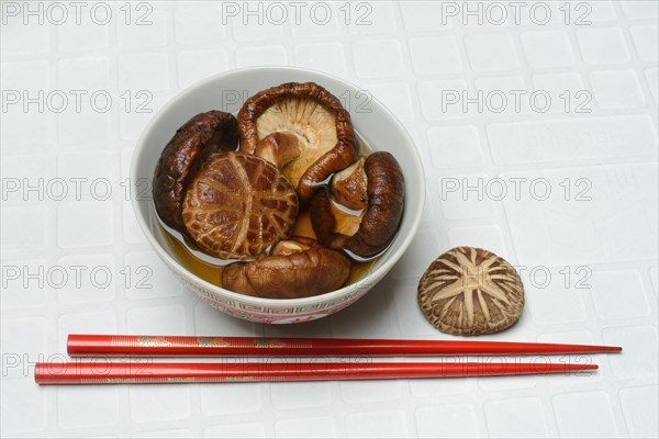 Dried shiitake mushrooms in a bowl, soaked in water