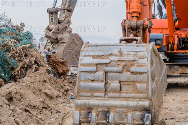 Closeup of bucked on backhoe parked at rural construction site on overcast day