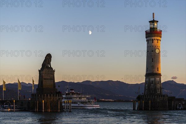 Lindau at Lake Constance, entrance to the harbour, Bavarian lion, new lighthouse, view of the Alps, passenger ship, half moon, evening light, Bavaria, Germany, Europe