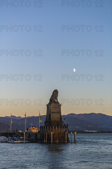 Lindau on Lake Constance, entrance to the harbour, Bavarian lion, pier, motorboats, view of the Alps, half moon, evening light, Bavaria, Germany, Europe