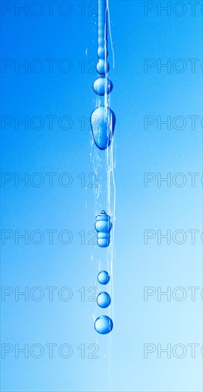 A thin stream of water from a sponge breaks off and begins to drip