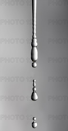 A thin stream of water from a sponge breaks off and begins to drip