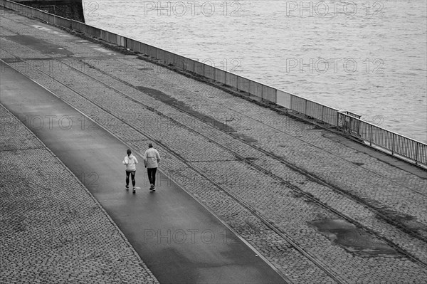 Two joggers on the banks of the Rhine, black and white, Cologne, Germany, Europe