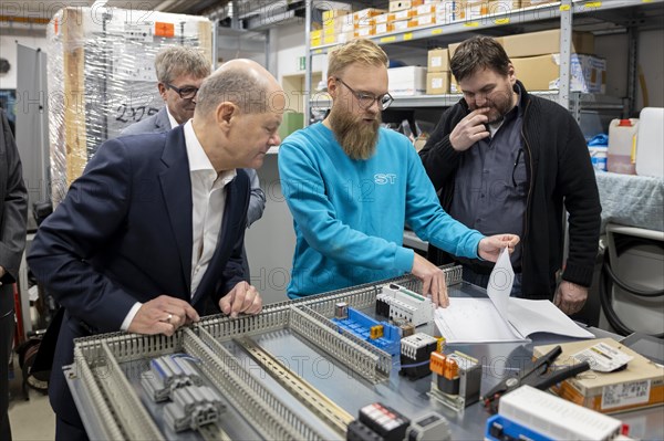 Federal Chancellor Olaf Scholz, SPD, visits the company ST Gebäudetechnik in Potsdam. Here in conversation with employees at a control cabinet. 20.01.2024