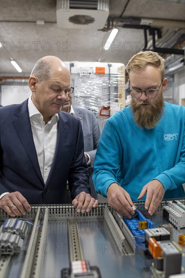 Federal Chancellor Olaf Scholz, SPD, visits the company ST Gebäudetechnik in Potsdam. Here in conversation with employees at a control cabinet. 20.01.2024