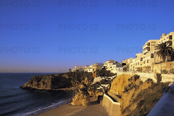 Apartments in early morning light under a deep blue sky overlook the deserted west end of the main beach at Albufeira, Algarve, Portugal, Europe