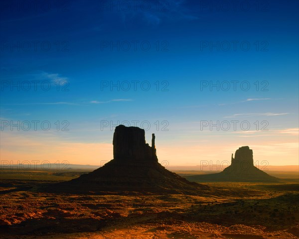 Elephant Butte seen across the desert-floor with thorn-scrub, other buttes in distance, Monument Valley, Utah/Arizona, USA, North America