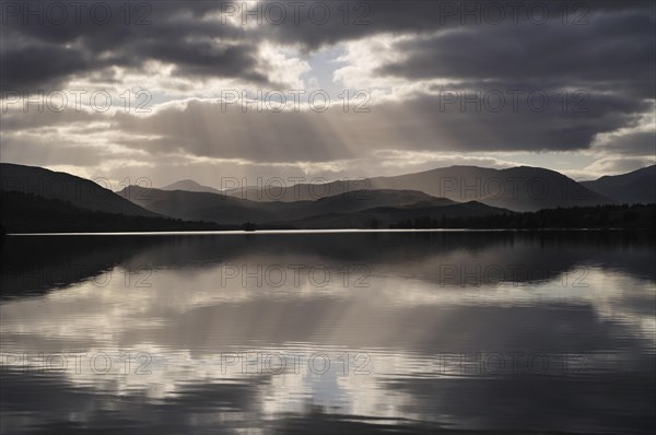 Sunrays and backlit clouds over Loch Tulla, Rannoch Moor, Scottish Highlands, UK