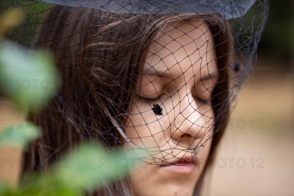 Close-up of a grieving young woman with a mourning veil (symbolic image)