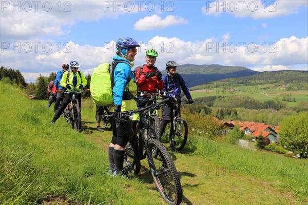 Participants of the Trans Bayerwald from the DAV Summit Club take a short break. In the background you can see the Osser, which marks the border between the Bavarian Forest and the Bohemian Forest