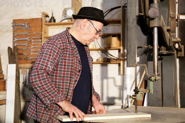 Furniture restorer works with a jigsaw