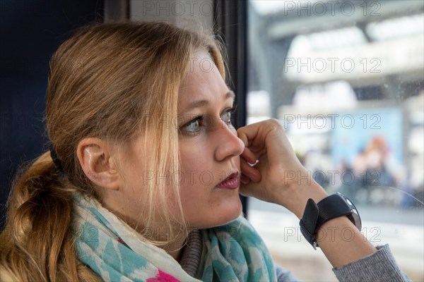 Young woman on the train gazes thoughtfully out of the window