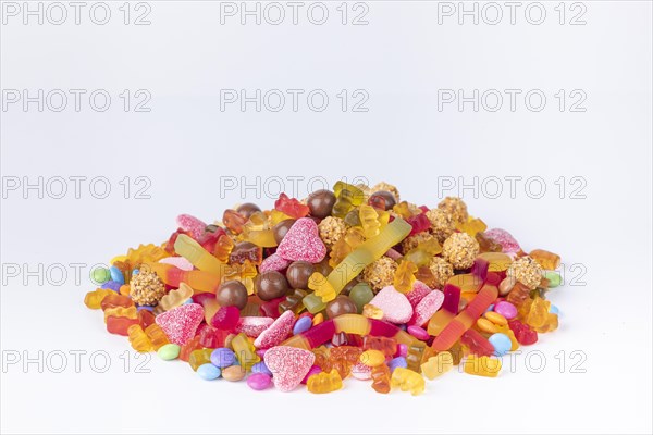 A colourful pile of different sweets on a white background, copy room