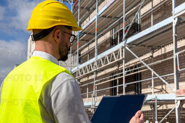 Symbolic image: Architect in front of an apartment block under construction