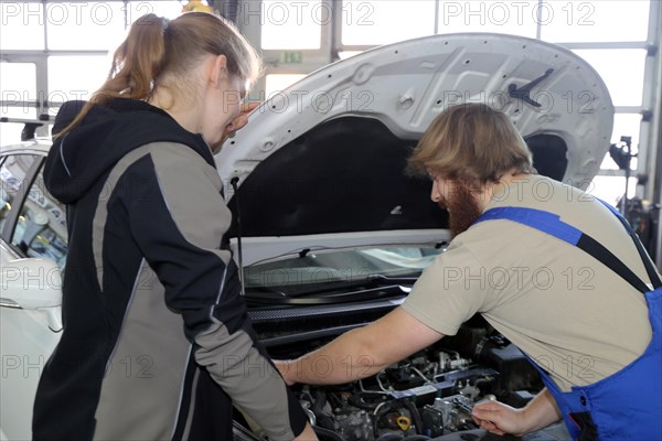 Symbolic image: Car mechatronics technician with customer in the garage