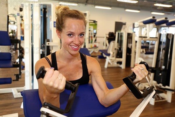 Young woman training on equipment in the gym