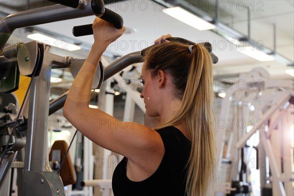 Young woman training on equipment in the gym