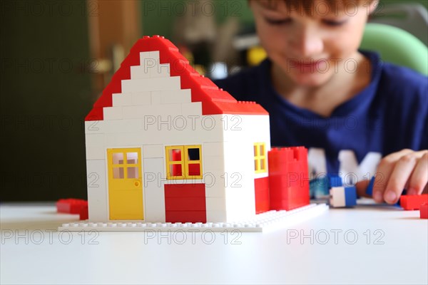 Symbolic image: Boy builds a house with building blocks