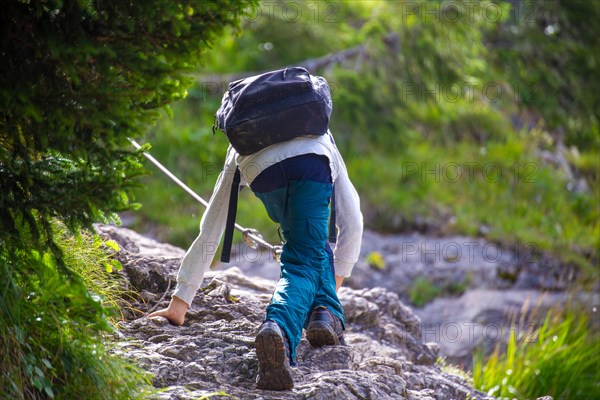 Hiking in the Allgaeu Alps: Boy on a passage secured with a wire rope on the ascent from the Richteralpe to Lake Gaisalpsee