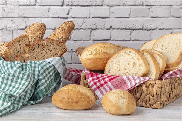 Fresh pastries and bread in two baskets in front of a brick wall