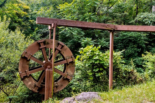 Wooden water trough and waterwheel in lush mountain recreational park in South Korea