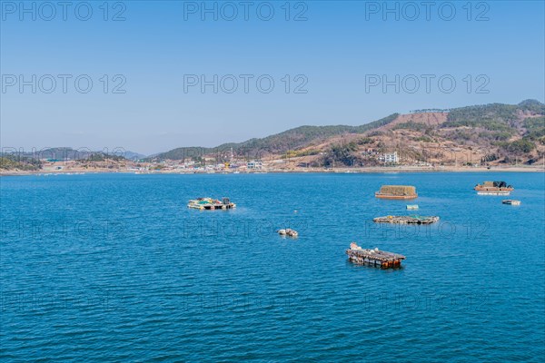 Floating docks loaded with fishing gear in water off island coastal seaport in Yeosu, South Korea, Asia