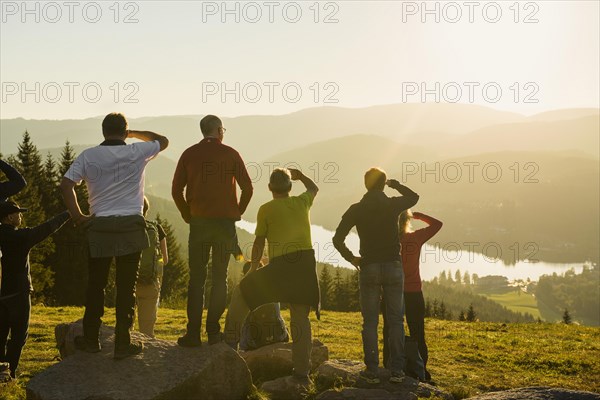 Hiking group, view from Hochfirst to Titisee and Feldberg, sunset, near Neustadt, Black Forest, Baden-Wuerttemberg, Germany, Europe