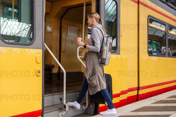 Young woman gets on a train