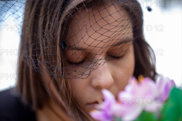 Close-up of a grieving young woman with a mourning veil (symbolic image)