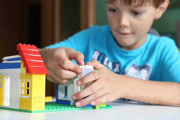 Boy builds a house with building blocks