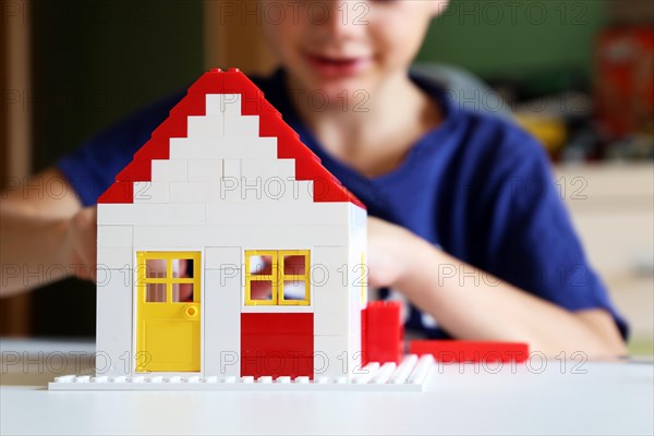 Boy builds a house with building blocks