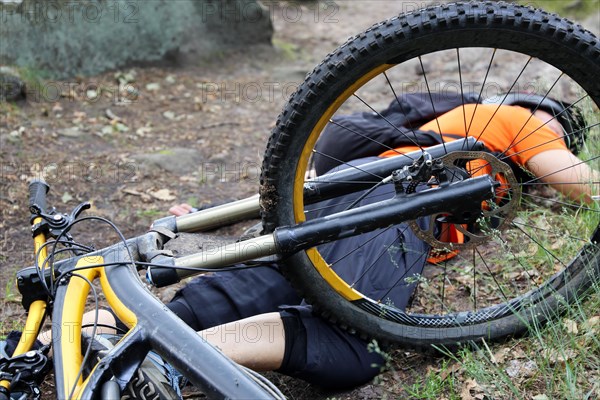 Injured mountain biker lying on the ground in an accident