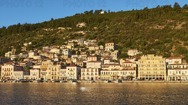 Dense development along the coast, glowing in the light of the morning sun, Gythio, Mani, Peloponnese, Greece, Europe