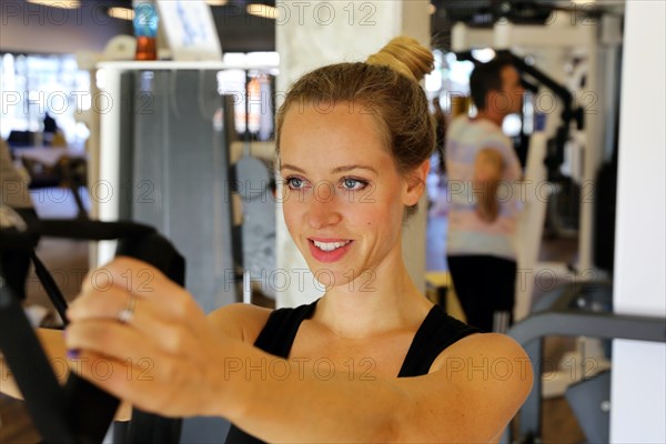 Young woman doing TRX training in the gym, (Neuhofen, Rhineland-Palatinate)