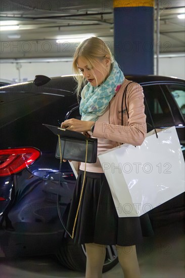 Elegant young woman in a car park