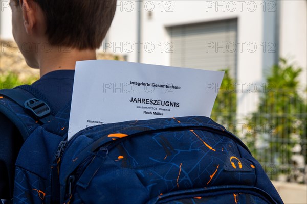 Symbolic image of report cards: Pupils at an integrated comprehensive school on their way home with their annual report cards
