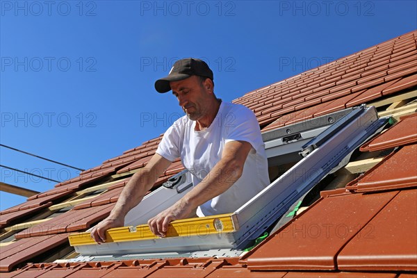 Employees of Zimmerei Mellein GmbH install the roof windows in the Mutterstadt development area, Rhineland-Palatinate