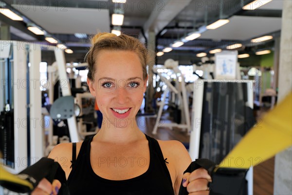 Young woman doing TRX training in the gym, (Neuhofen, Rhineland-Palatinate)