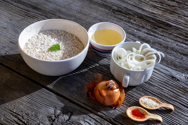 Raw Ingredient to Make the Saffron Rice, Risotto alla Milanese with Parmesan Cheese and White Wine and Onion and a Heart Shape Leaf on an Old Wood Table with Sunlight in Lugano, Ticino, Switzerland, Europe