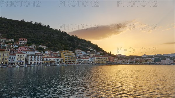 Town view at dusk with houses on the waterfront and mountains in the background, Taygetos Mountains, Taygetos, Gythio, Mani, Peloponnese, Greece, Europe